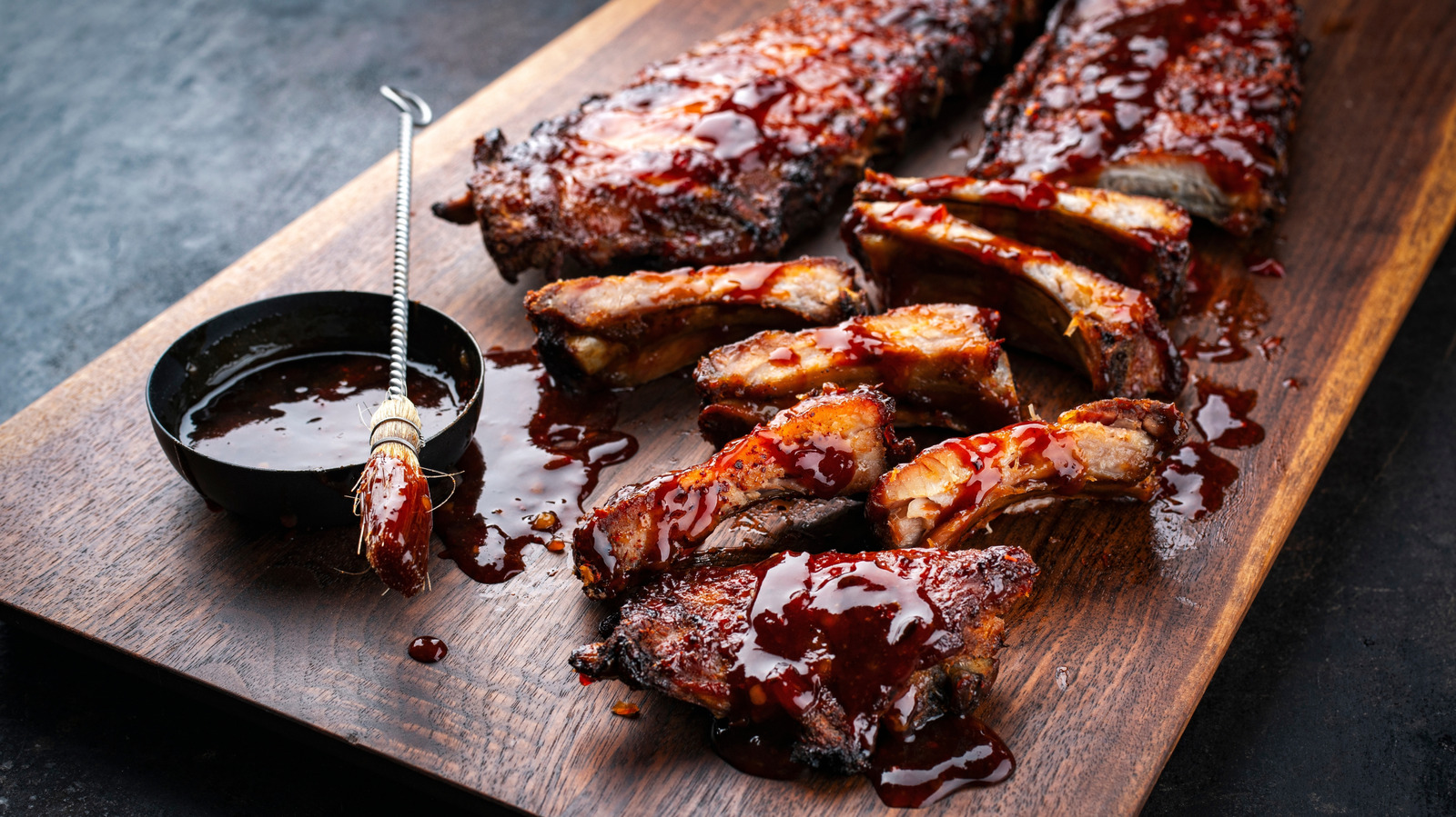 Slow-cooked BBQ ribs glazed in sweet-smoky sauce on a wooden board
