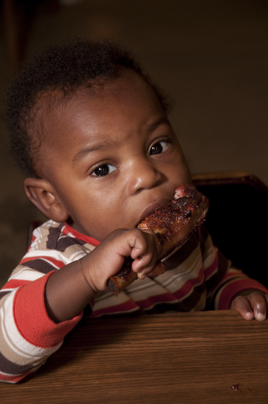 Little one happily eating a piece of Melba's fried chicken